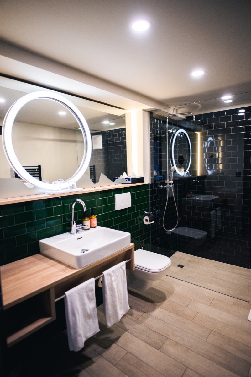 Renovated bathroom with dark tile and warm wood vanity